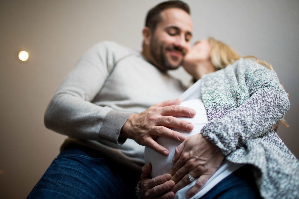 Dad holds woman's belly bump for professional photo